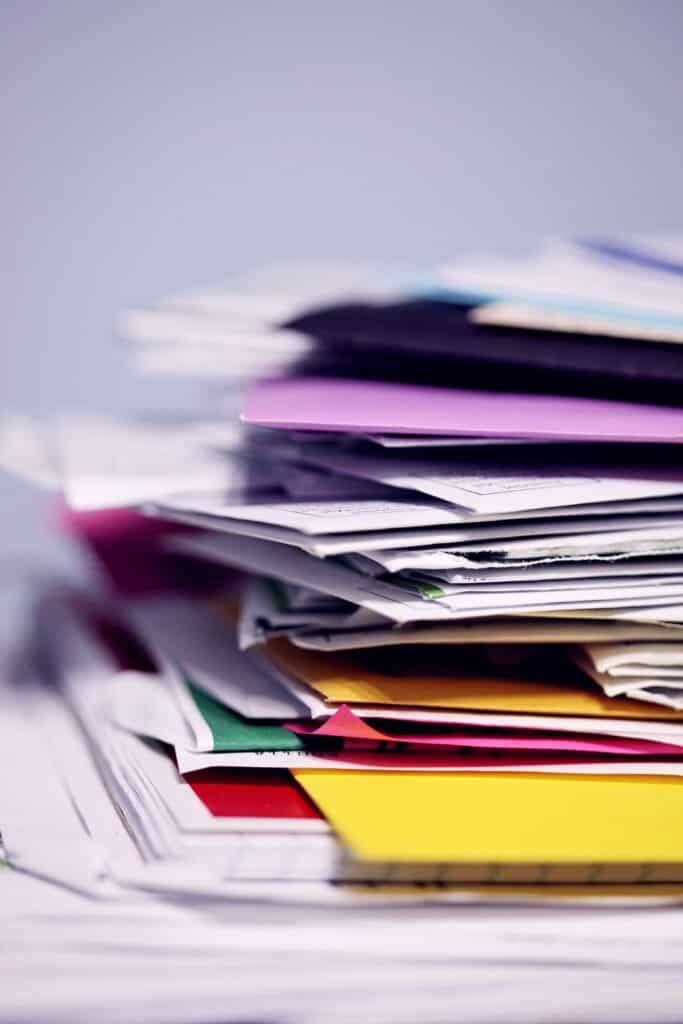 Messy stack of colorful documents and file folders.