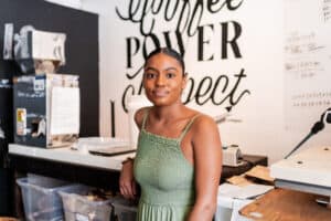 Cortney leans on her coffee shop's counter
