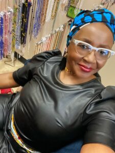 Ethea poses with her waistbeads behind her 