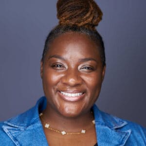 Headshot of Kartisha Henry in a blue shirt, smiling at the camera