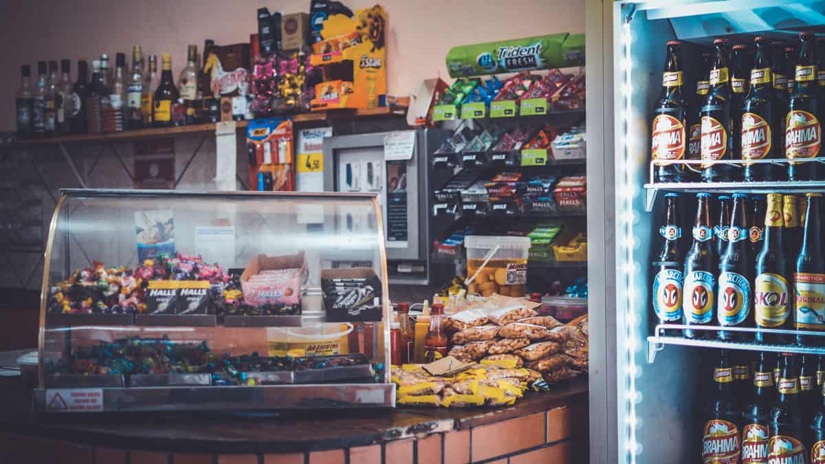 Retail store interior with a number of products placed on display, in a refrigerator, on the counter and in a display cabinet, showing what product placement is.