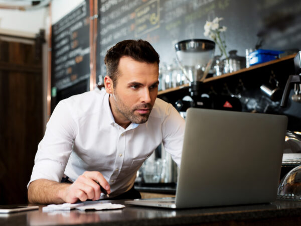 Restaurant owner working on laptop, choosing small business loan type