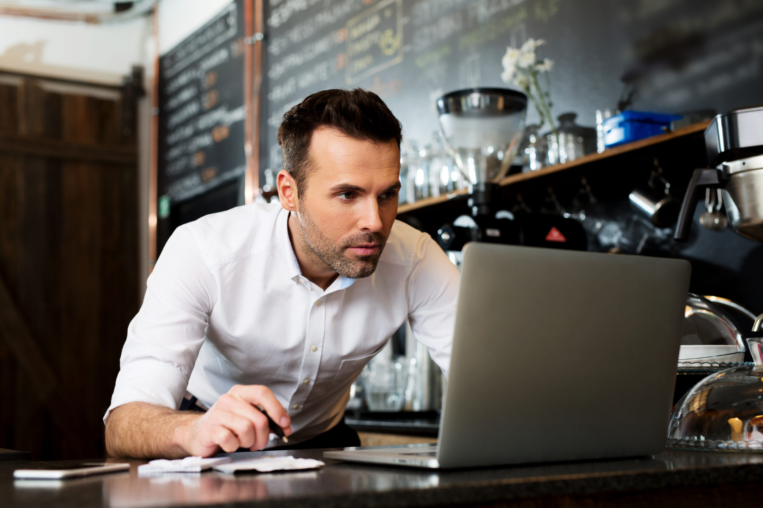 Restaurant owner working on laptop, choosing small business loan type