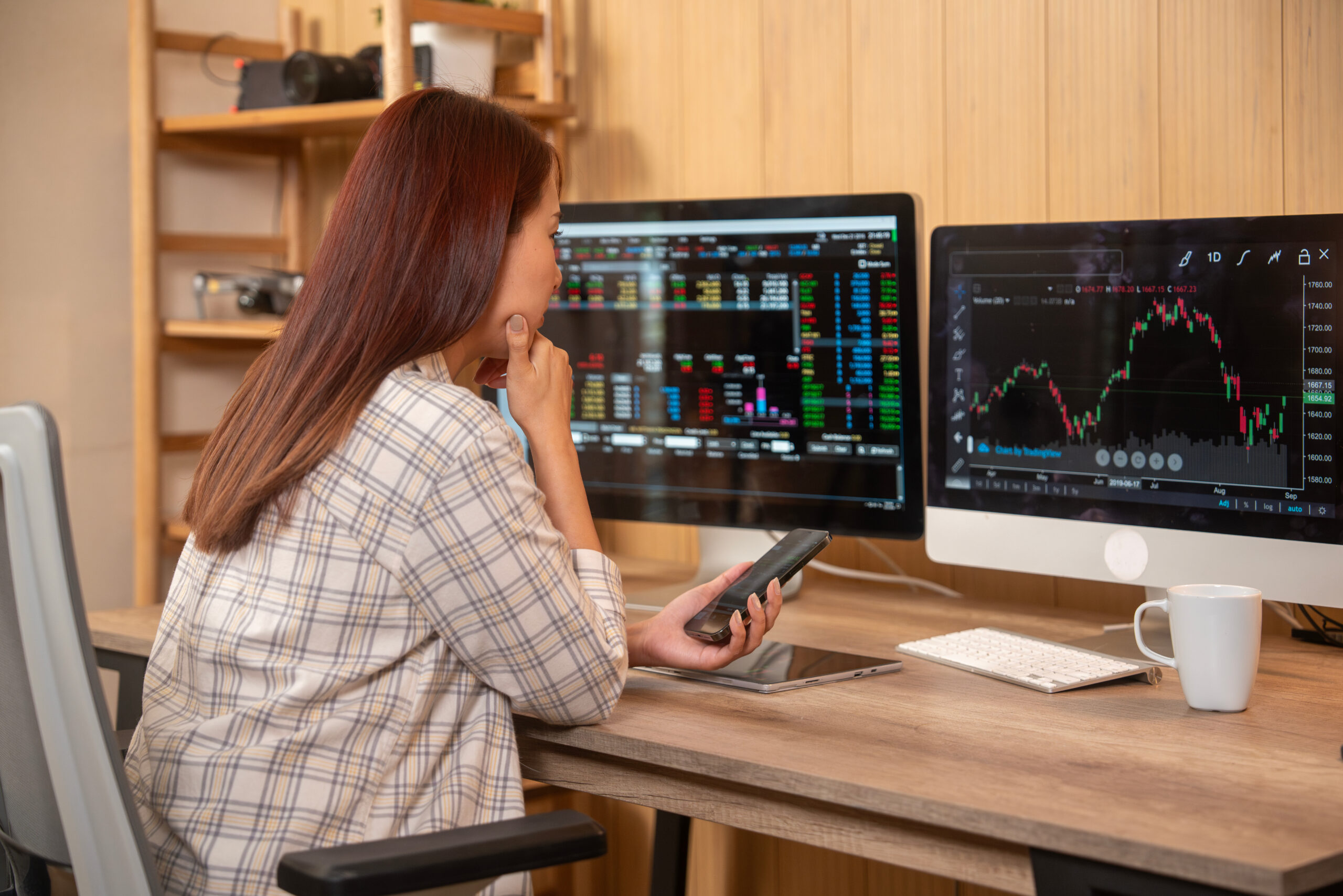 Young woman doing cryptocurrency business trading on her computer at home at night
